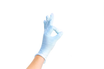 Female hands in white medical gloves showing okay sign. 