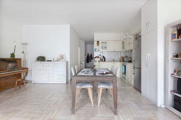 Fototapeta na wymiar Modern bright domestic dining room interior with open kitchen