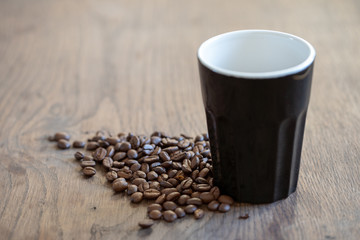 coffee cup on table surrounded by coffee beans