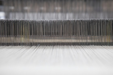 Yarn thread lines on the weaving loom machine. A loom machine for clothing or woven label. Weaving...