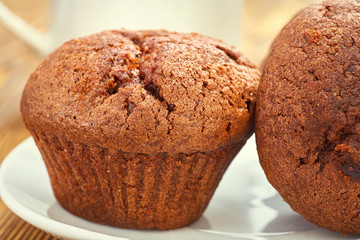 Dark chocolate dough muffin on the background of an old wooden table.