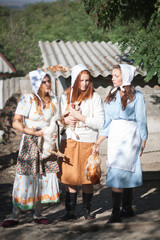 Fototapeta premium Three women with poultry in their hands.