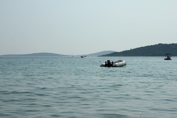 A picture of several boats floating on the blue ocean during the hot summer day. Relaxing vacation activity for the people. 