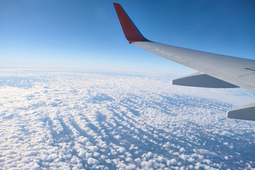  Wing aircraft on the background of beautiful clouds. The view from the top. Comfort during the...