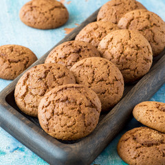 Homemade baking. Oatmeal cookies on a wooden tray on the old table. 