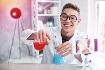 Handsome student studying chemistry feeling happy after successful experiment