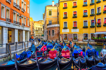 Narrow canal with gondolas and bridge in Venice, Italy. Architecture and landmark of Venice. Cozy cityscape of Venice.