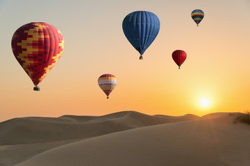 Sunset in desert, hot air balloons in sky