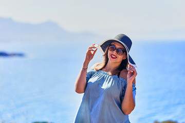 Beautiful woman in beach hat enjoying sea view with blue sky at sunny day in Bodrum, Turkey. Vacation Outdoors Seascape Summer Travel Concept