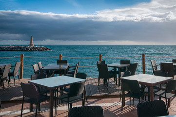 black table and chairs in the restaurant on the beach against the lighthouse