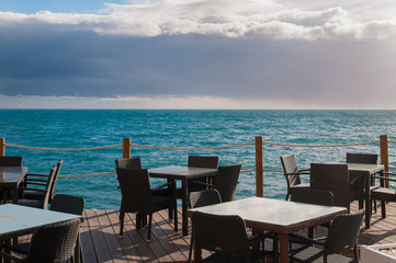 table and chairs in a restaurant by the sea