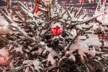 red ball on snow-covered Christmas tree