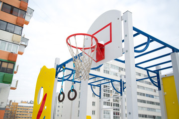 Modern beautiful Playground in the new area on the background of multi-storey buildings in winter