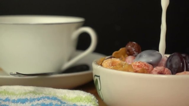 Pouring fresh milk to a bowl of cereal breakfast, Slow Motion