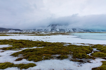 Isländische Winterlandschaft mit Bergen, See und Moos