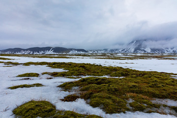 Isländische Winterlandschaft mit Bergen, See und Moos