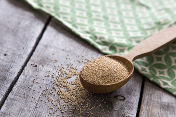 Amaranth seeds in a wooden spoon on table, selective focus. Raw Organic Amaranth Grain