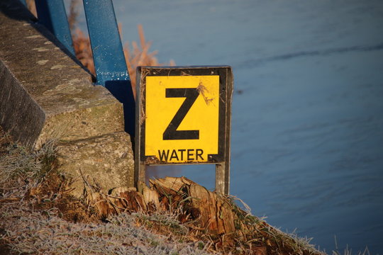 Yellow warning sign with letter 'Z' to warn that a water pipe have sunken on the bottom of the canal.