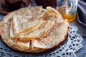 Fishnet thin pancakes on the table with a napkin, horizontal