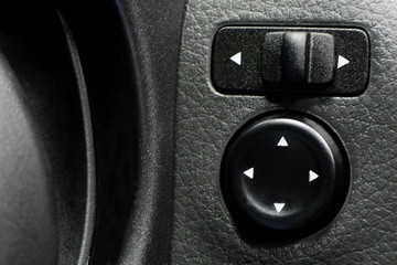 Modern car side mirrors control buttons close up.