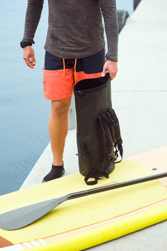 Sportsman standing on the dock with a nearby stand up paddle board