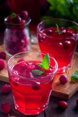 Refreshing vitamin cranberry drink in glass cups on a wooden table, selective focus