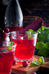 Refreshing vitamin cranberry drink in glass cups on a wooden table, selective focus
