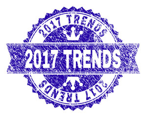 2017 TRENDS rosette stamp overlay with grunge style. Designed with round rosette, ribbon and small crowns. Blue vector rubber print of 2017 TRENDS text with grunge texture.