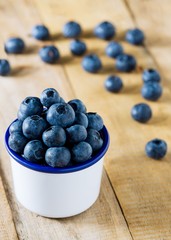 Pile of blueberries in the cup on table fresh fruit background