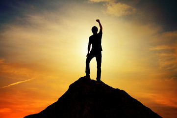 Man standing on top mountain and sunset backgrond outdoor on nature ,leader success winner business...