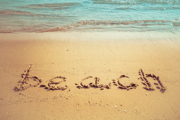 Vacation on the sand beach concept. Beach words written into the sand on the beach at Rayong, Thailand.