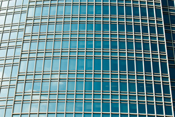 Fototapeta premium Abstract Windows Glass Fragment of Building architecture, pattern of window frame for office tower reflect other building skyscraper in day time blue sky background
