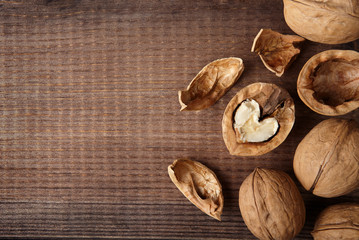 Walnut with heart-shaped core and whole walnuts on wooden background with copy space. Top view.