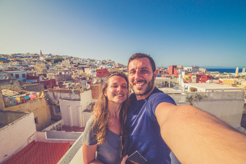 happy tourist take selfie with the cityscape of the medina of Tanger, Morocco. Colors of sunset