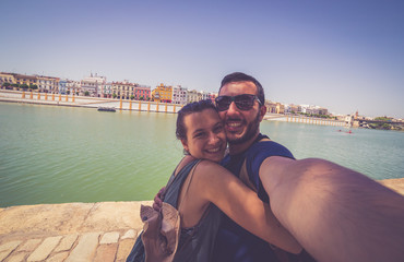 happy smiling couple take photo selfie in Spain square (plaza de espana) in Sevilla, Spain
