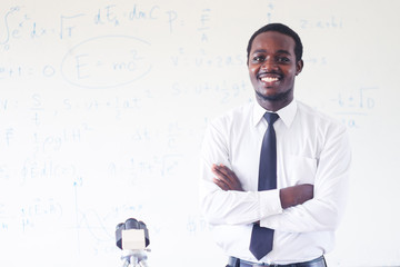 African science teacher teaching and smiling in the stem class with microscope.