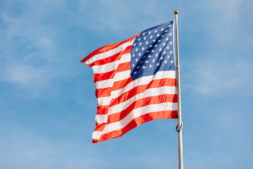 American flag on the blue sky with clouds