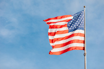 Obraz premium American flag on the blue sky with clouds