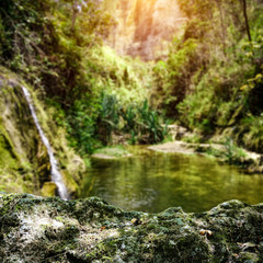 Exotic waterfall background with green moss space for your product. Summer time on Madagascar 