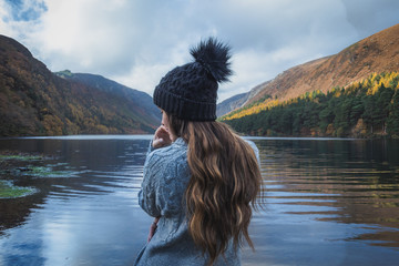 Woman standing on the edge of Upper Lake in Glendalough Ireland