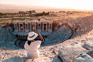 Hierapolis ancient city Pamukkale Turkey, young woman with hat watching sunset by the ruins Unesco 