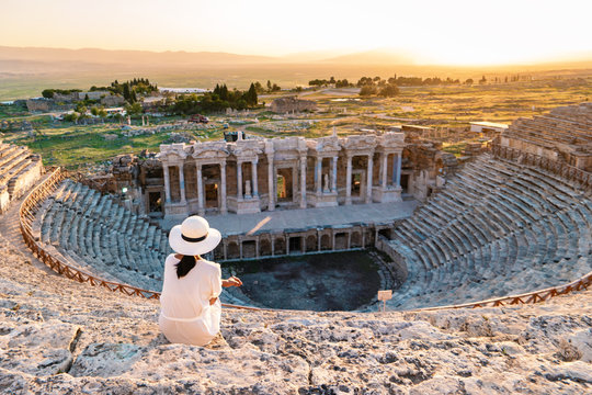 Hierapolis ancient city Pamukkale Turkey, young woman with hat watching sunset by the ruins Unesco 