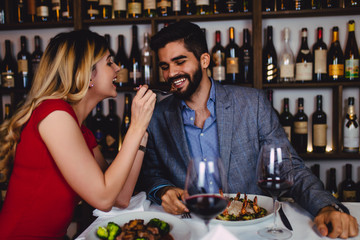Beautiful young romantic couple dating at night in restaurant.