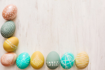 decorated easter eggs on white wooden background