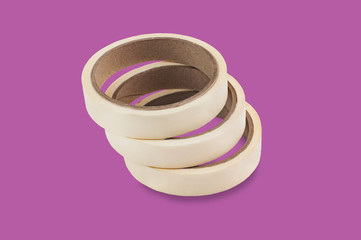 Rolls of adhesive paper tape in center on purple background