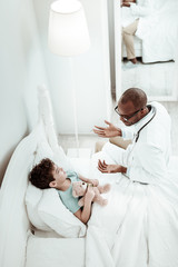 Fototapeta premium Pleased brunette boy listening to his doctor
