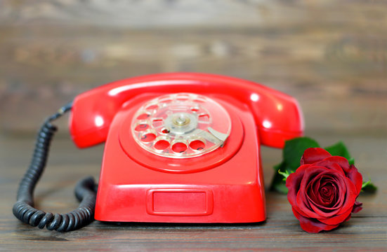 Vintage telephone and red rose