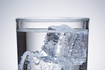 Fresh cold water with ice. Glass of water close up.