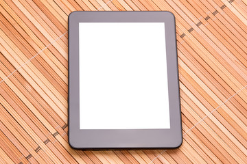 Tablet computer with a white screen under the text. Tablet computer on a wooden background.