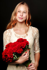 A teenage girl with a bouquet of flowers, on a black background.